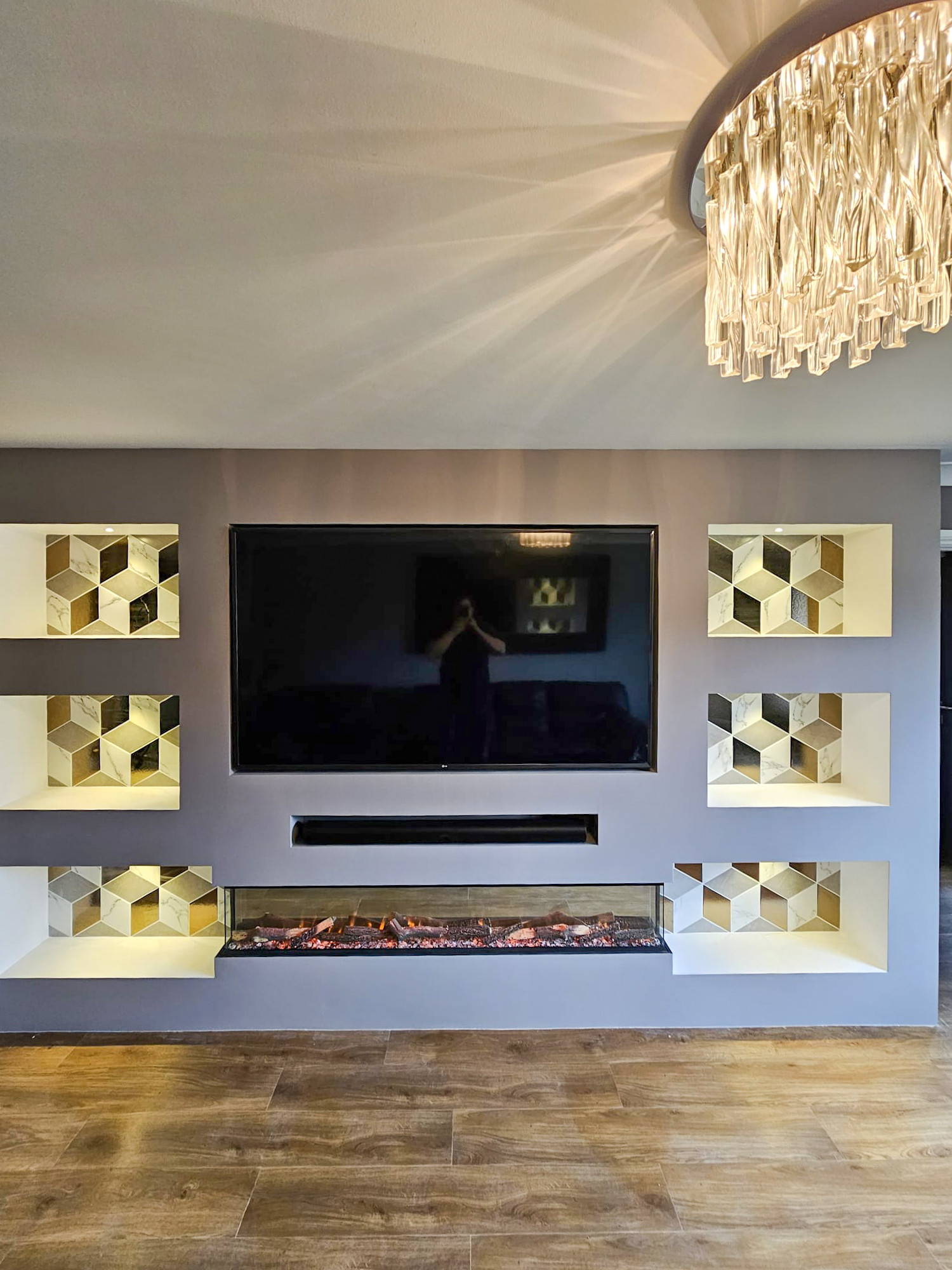Finished media wall with a television panel and a discreet console